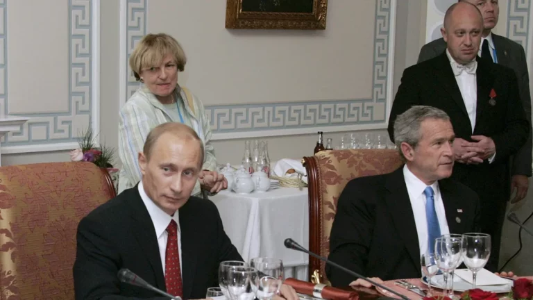 Президент России Владимир Путин (слева) и президент США Джордж Буш присутствуют на рабочем ужине с другими лидерами стран «Большой восьмерки», российский бизнесмен Евгений Пригожин стоит справа, 19 июля 2006 года