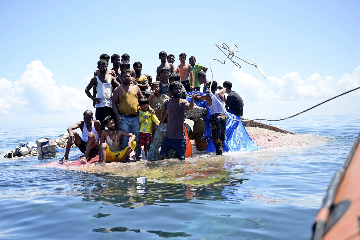 Беженцы рохинджа ожидают помощи на опрокинутой лодке. Фото дня