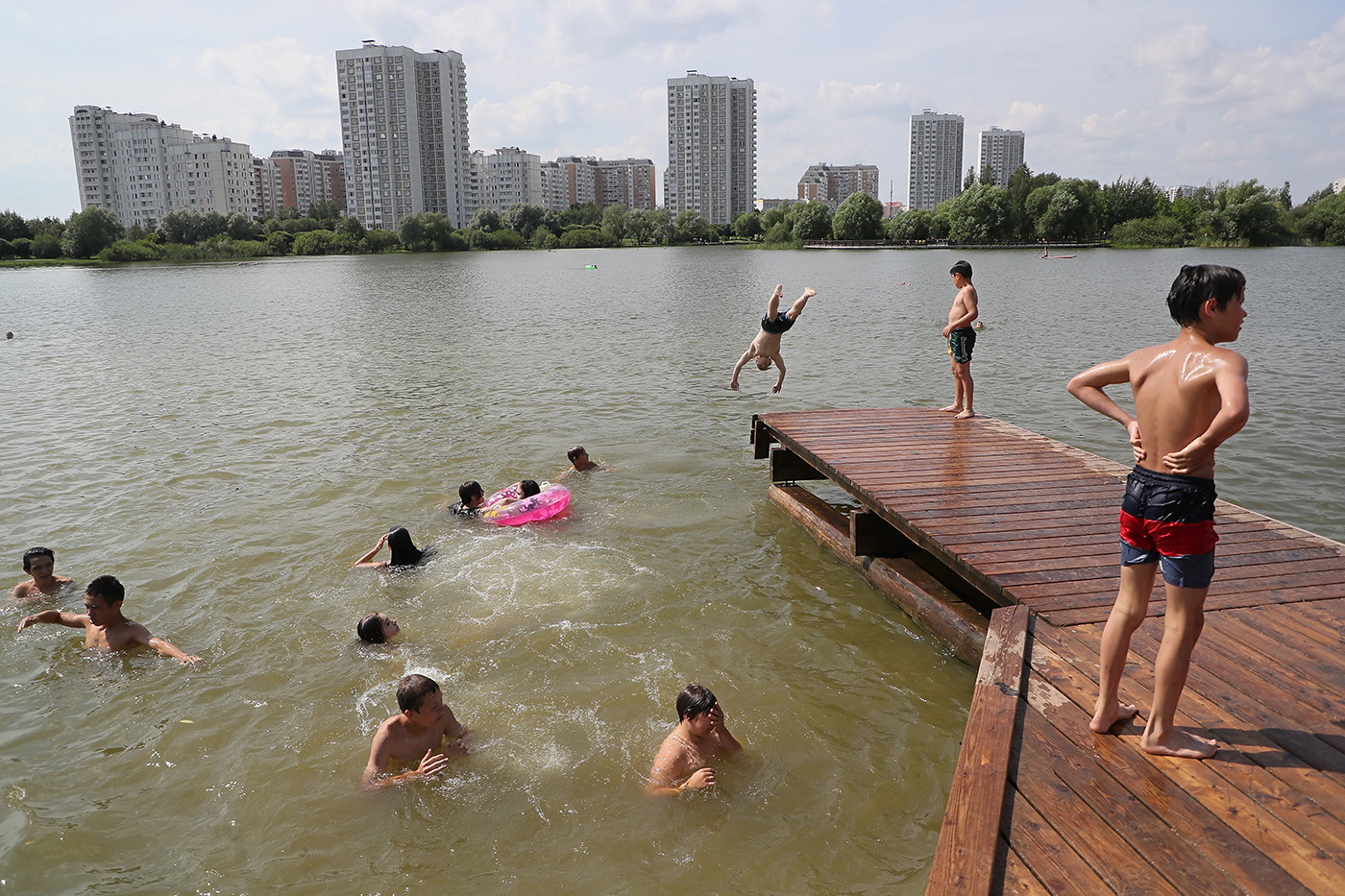 Люди жарким днем на пруду в Москве. Фото дня