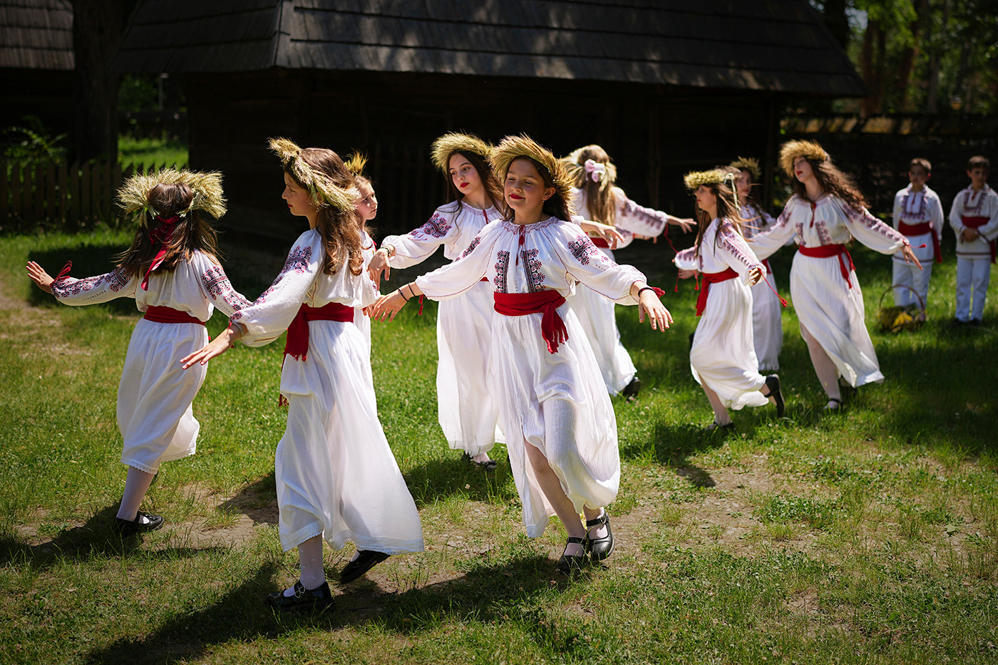 Девушки в цветочных венках танцуют во время мероприятия, вдохновлённого дохристианскими традициями, в ходе которого, согласно поверью, феи спускаются на землю в период летнего солнцестояния, принося плодородие земле и живым существам. Событие проходит в Музее села имени Димитрия Густи в Бухаресте, Румыния, 24 июня 2025 года