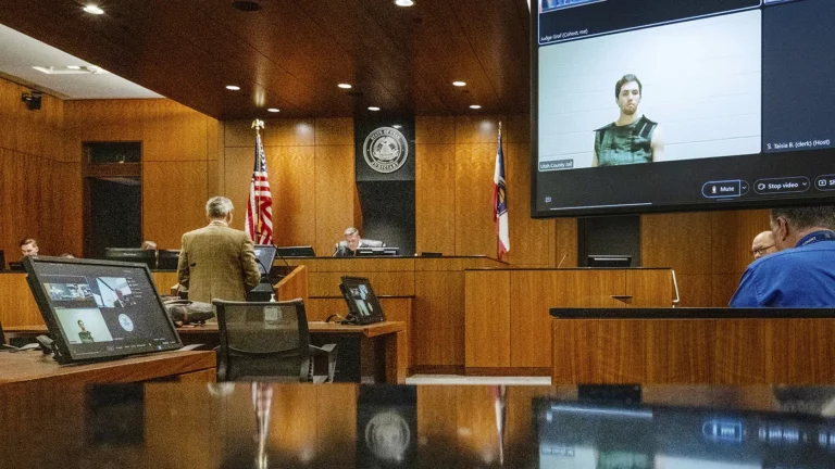 Тайлер Робинсон (на мониторе справа), обвиняемый в убийстве Чарли Кирка, присутствует на судебном заседании виртуально из тюрьмы