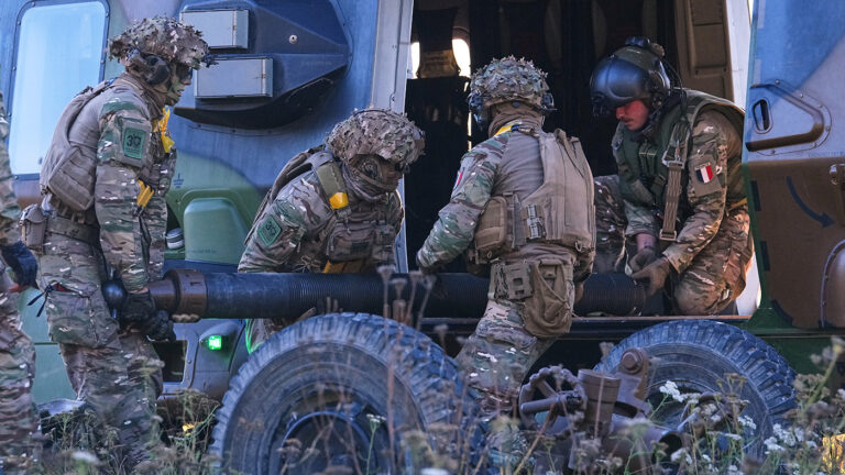 Французские военнослужащие выгружают 120-мм миномет из вертолета NH 90 Caiman  во время международных военных учений на острове Сааремаа, Эстония